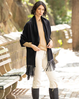Woman wearing a Cashmere Wrap with Leather Fringe in black outdoors