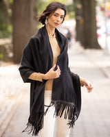 Woman wearing a Cashmere Wrap with Leather Fringe in black outdoors