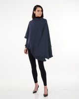 model wearing volant cashmere cape with ruffles in navy and leggings and heels