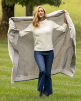 model holding Skyline Border Stripe Cashmere Throw in grey