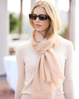 Woman in a sweater and sunglasses with a St Tropez lightweight cashmere wrap in Champagne