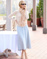 Woman in sunglasses, a sweater and skirt with a St Tropez lightweight cashmere wrap in Champagne