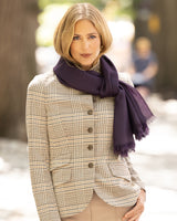 Woman wearing a plaid jacket and Lightweight cashmere wrap in Dark Currant outdoors