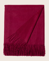 Burgundy throw blanket with fringes on a beige background