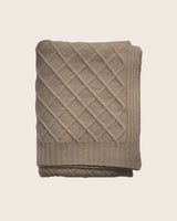 Folded beige cashmere blanket with diamond pattern in heather taupe