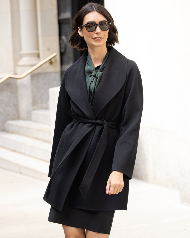 Woman wearing a Victoria cashmere belted coat in black and sunglasses in an urban setting