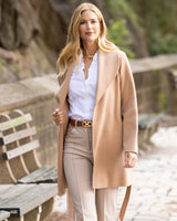 Woman in a Victoria Coat in camel front walking outdoors.