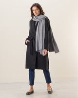 Woman wearing Voyage Cashmere Travel Wrap in grey over cashmere coat
